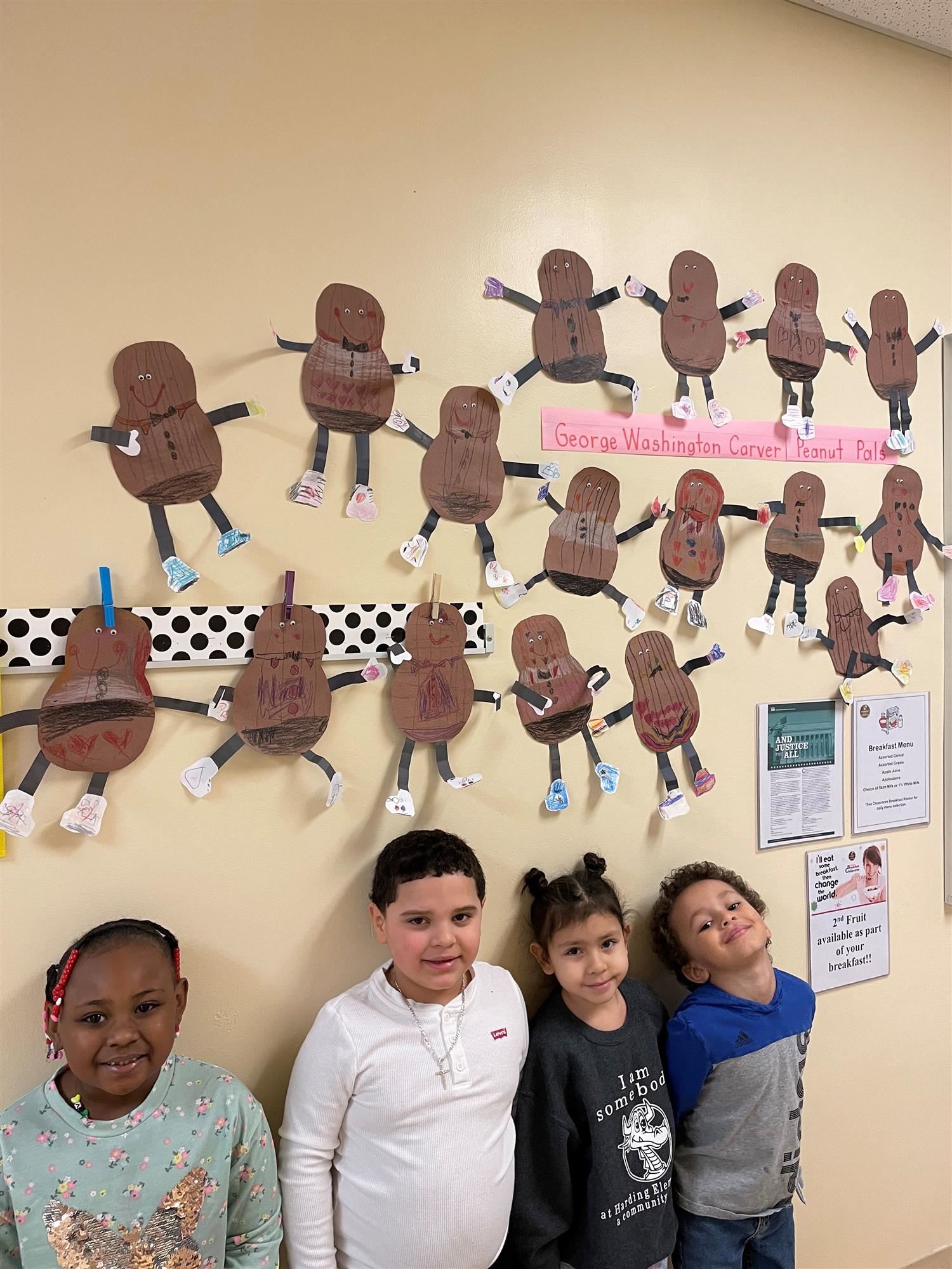 Students standing in front of a wall decorated with peanuts made out of construction paper in honor of Carver.